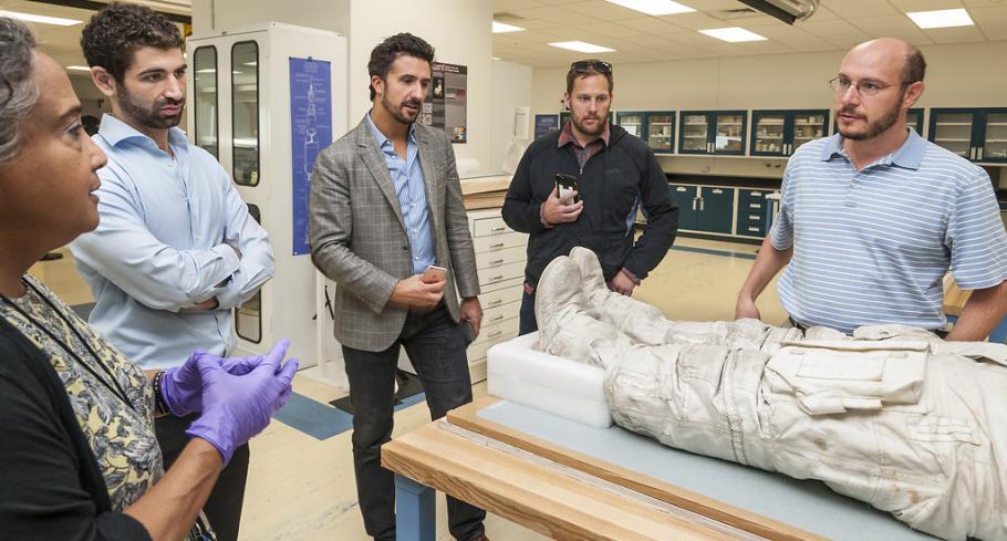 A group of backers of a Kickstarter campaign to restore the spacesuits of Neil Armstrong and Alan Shepard receive a behind the scenes look at Armstrong's spacesuit with a Museum curator (left) as a Kickstarter benefit.